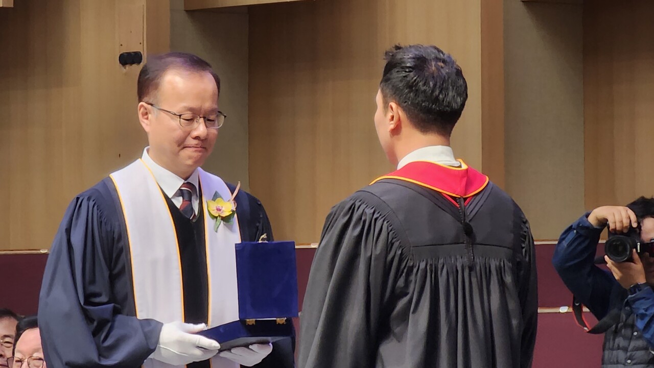 김승욱 연합회장(좌)에게 목사안수패를 수여받고 있는 박완수 목사(우)