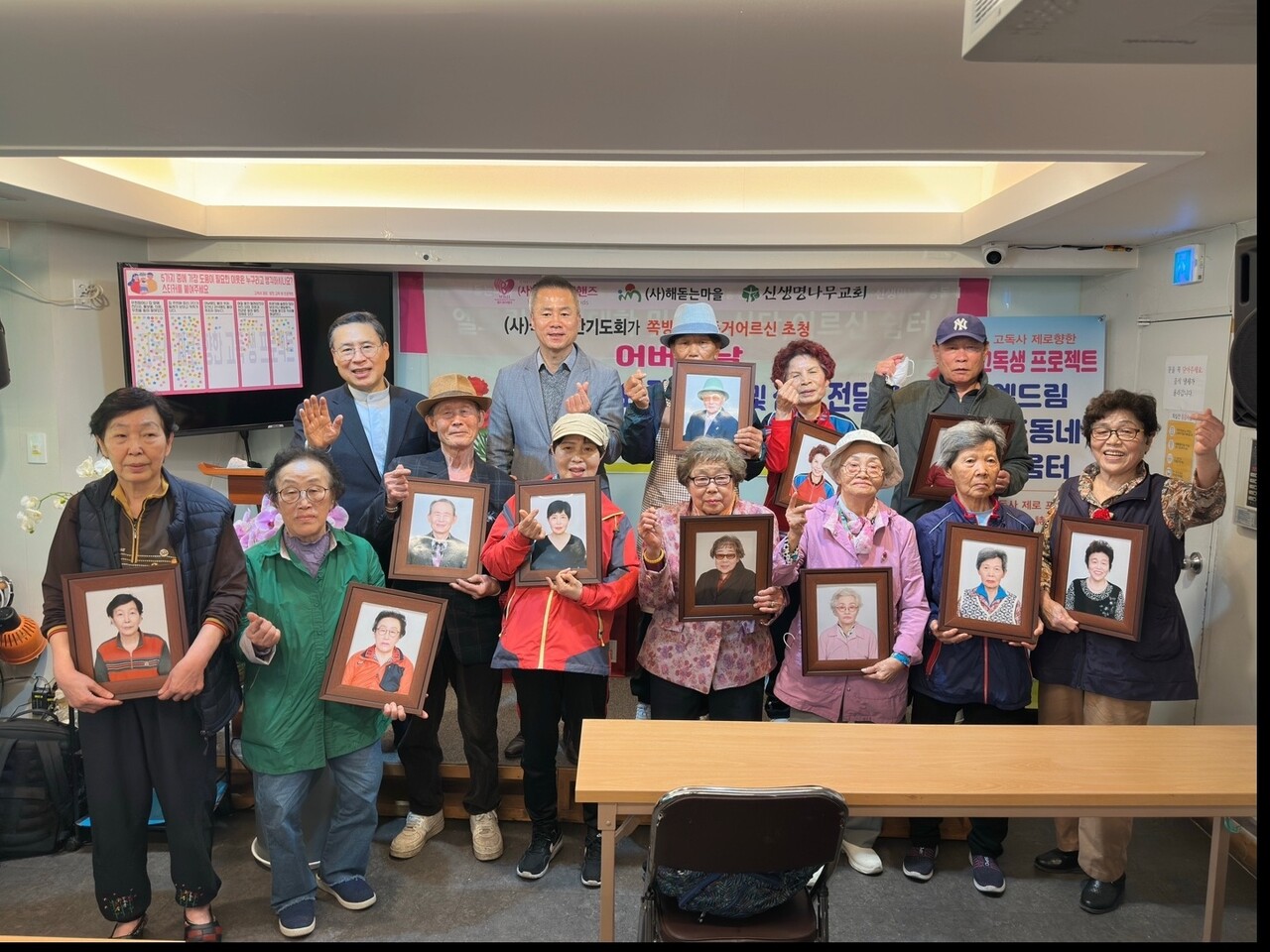 국가조찬기도회가 쪽방촌과 독거어르신을 위한 온전한 사랑을 나눴다. 사진은 장수사진을 들고 하트를 날리는 모습.